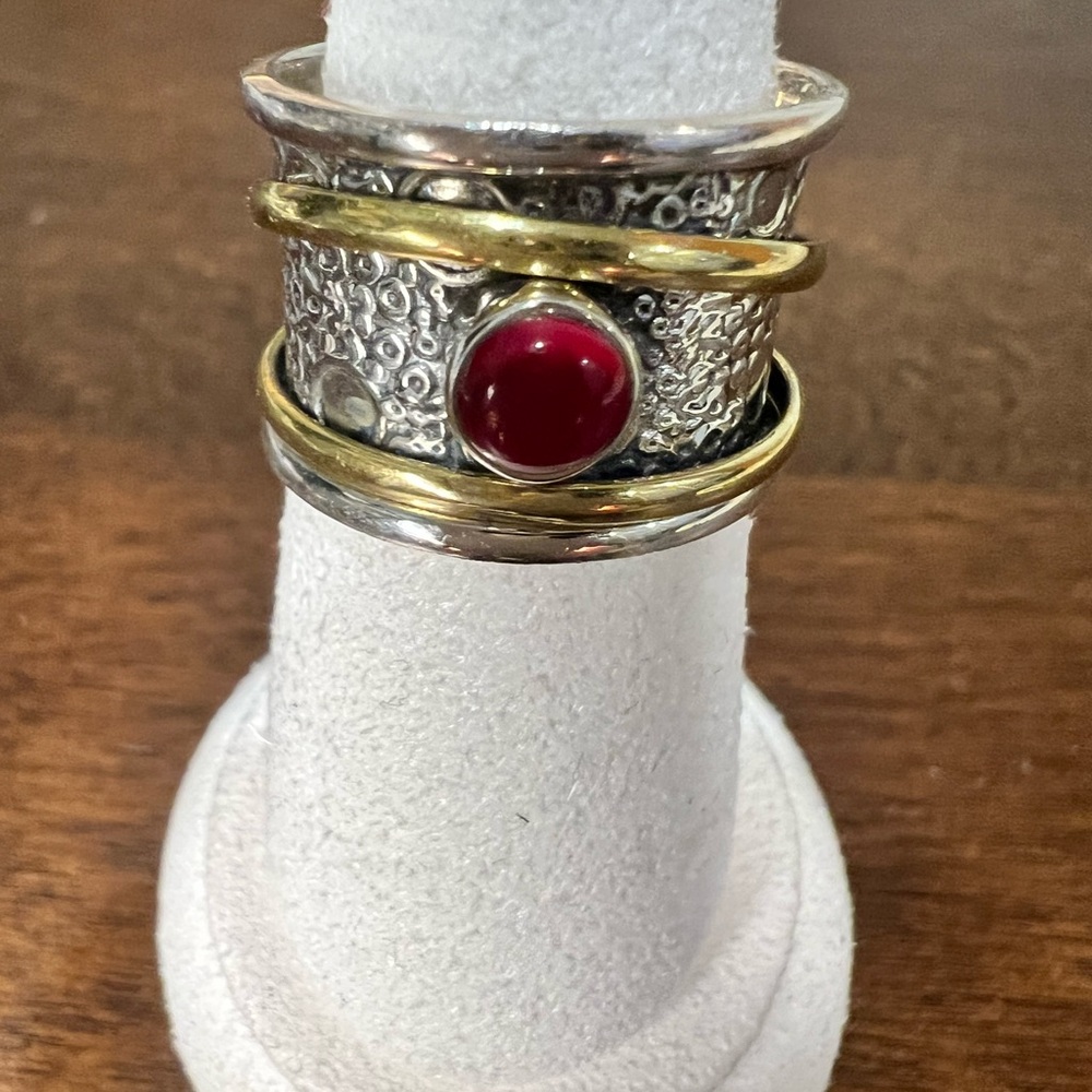 Sterling silver with 2 brass spinner rings with red cabochon stone. Size 8